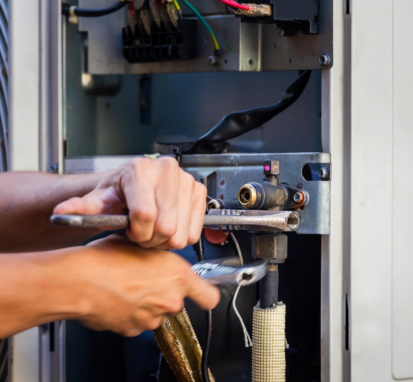 A worker working on a furnace with some tools