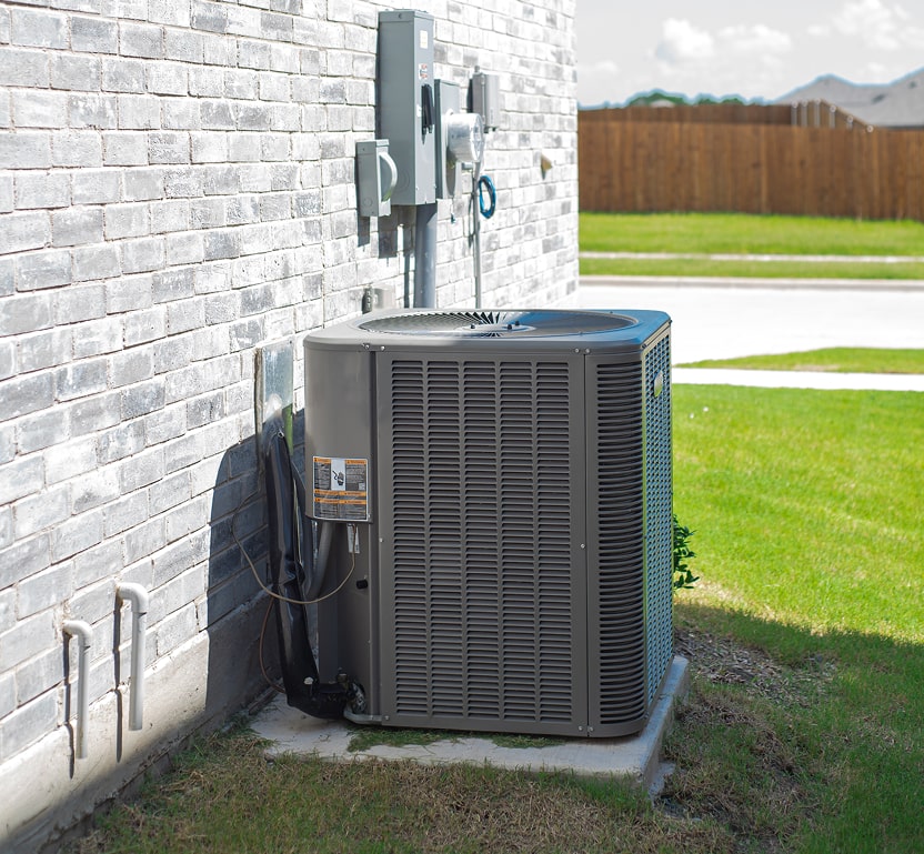Outdoor condensing unit seen from the side of a house