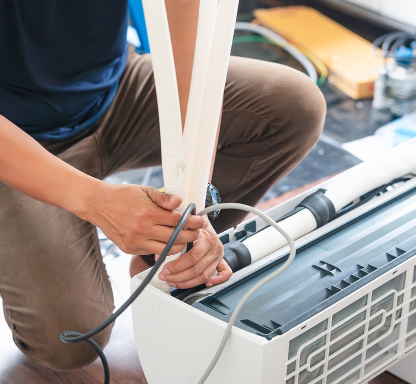 a minisplit ac system being worked on by a worker